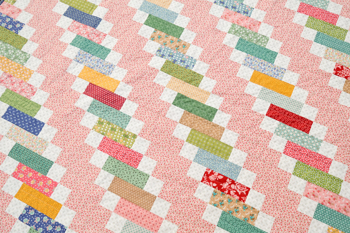 A modern traditional quilt using Home Town by Lori Holt for Riley Blake Fabrics and the Ruby Quilt Pattern by Kitchen Table Quilting. This pattern uses a Jelly Roll for a fun, quick, beginner-friendly pattern. 