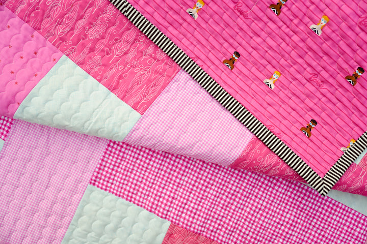 Handmade quilt with pink fabric and decorative scallop stitch, inspired by Barbie’s 1959 iconic swimsuit