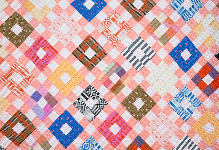 Finished Lydia Quilt made with Swedish Holiday fabric collection by The House That Lars Built, featuring bold plaids, stripes, and vibrant colors, paired with Cotton Couture accents and a Fableism Sprout Wovens backing in Sun Glow.